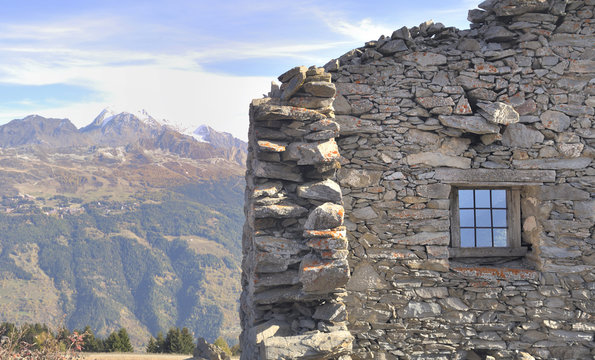 wall of ancient sheepfold in front of mountain landscape 