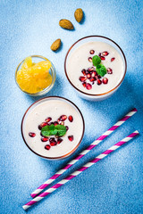 Winter detox pomegranate citrus smoothie on light blue background. Top view, copy space.