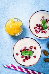 Healthy yogurt winter friut smoothie on blue background. Top view, copy space.