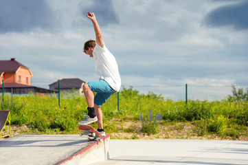 Fototapeta na wymiar A boy in a skate park doing a trick on a skateboard