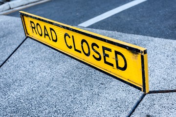 A yellow ROAD CLOSED sign in the middle of road.