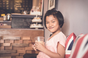Asian girl smiling happily, is drinking cold cocoa in the cafe shop.