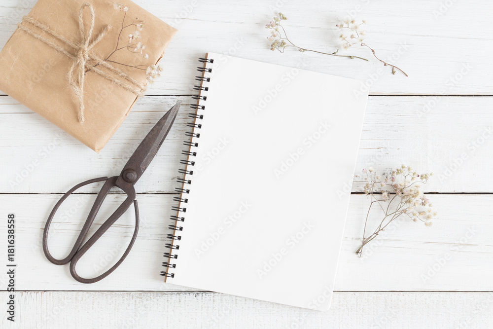 Wall mural flat lay photo of blank whtie notebook and scissors on whtie table