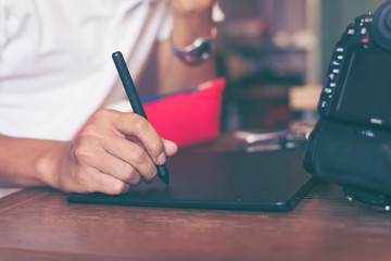 Graphic designers or photographers, working with the pen mouse and laptop on a wooden table in the home office, Concept of freelance graphic design and photographers