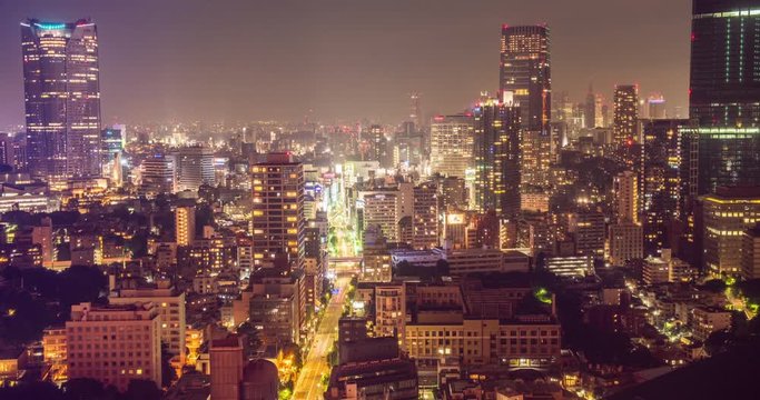 TOKYO, JAPAN – JUNE 2016 : Timelapse of central Tokyo cityscape at night with tall buildings in view, shot from Tokyo Tower