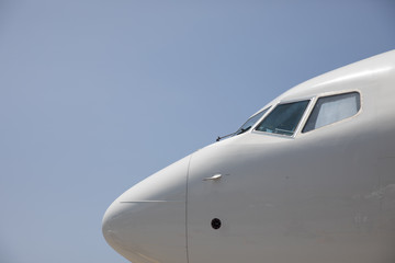 The nose of a plane against a blue sky