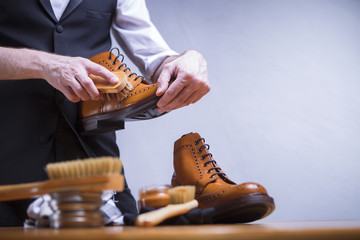 The process of cleaning shoes. A man is cleaning his shoes.