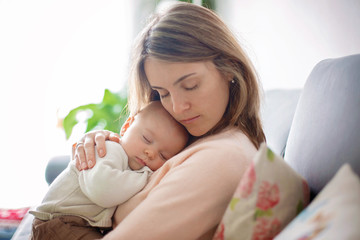 Young mother, holding tenderly her newborn baby boy © Tomsickova