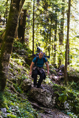 Hiker with backpack on a trail in the mountain forest