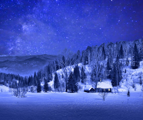 Small wooden house  in a night winter mountain landscape  with a beautiful starry sky