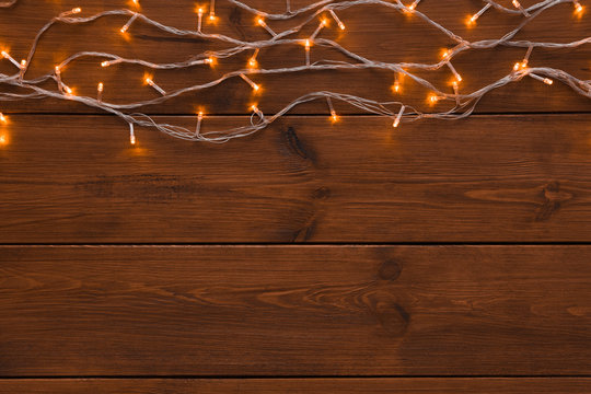 Christmas lights border on wood background