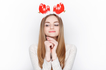 Beautiful emotional blonde female model wear santa deer headpiece. Christmas greetings concept.