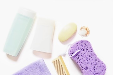 Flat lay organic bath products/ Shampoo, shower gel, terry towel, baby soap, wooden hair brush and purple sponge