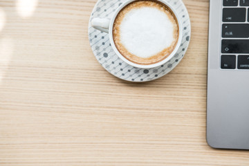 computer notebook, coffee cup on wood desk. laptop at office workplace.