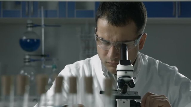 Scientific researcher using microscope in the lab