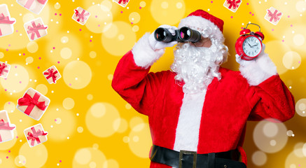 Santa Claus holding binoculars and alarm clock