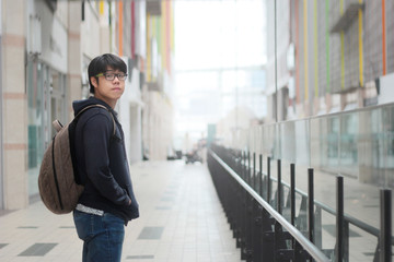 Fototapeta premium Male teenagers wear long-sleeved shirts dark pants standing and look back in corridor.