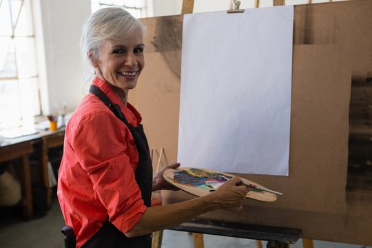 Portrait of smiling senior woman holding color palette