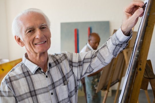Portrait of smiling senior man painting