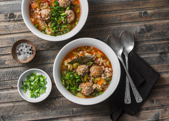 Multi grain, meatballs and vegetables soup  on a wooden rustic background, top view. Comfort home cooking healthy seasonal food concept