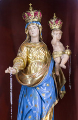 Fototapeta na wymiar Casorate Primo, Italy. October 26 2017. Statue of Virgin Mary the Queen holding baby Jesus Christ. San Vittore Martire Church (Church of Saint Victor Maurus - the Moor - the martyr - church)