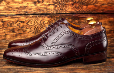 Brown man's shoes brogues on wooden background