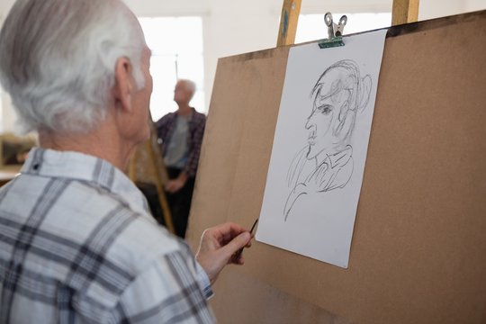 Close up of senior man drawing sketch of woman