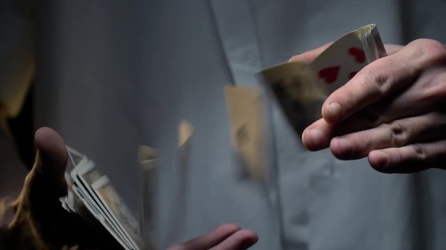 Men's hands show a trick with flying cards, slow motion