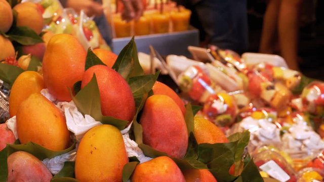 BARCELONA, SPAIN, SEPTEMBER 22, 2017: Showcase with Fresh Tropical Fruits and Vegetables in La Boqueria Food Market. Barcelona, Spain. Buyers of fruits and vegetables at the Mercat de Sant Josep.