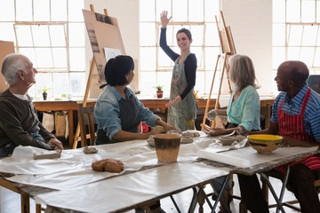 Senior man and woman looking at female instructor gesturing