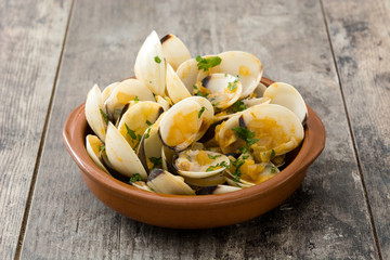 Clams with marinera sauce.Almejas a la marinera. Spanish recipe on wooden table