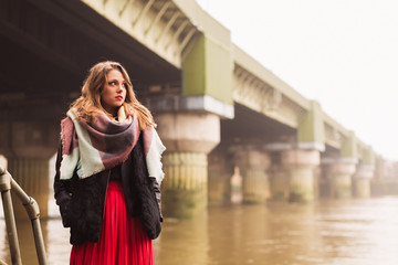 Fototapeta premium Portrait of young pretty woman who standing by the river and looking aside