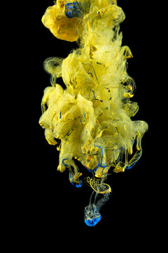 Macro close-ups of colorful liquids that appeared for a brief second when the flow of color drops spread underwater. A colorful mix of fluids is Isolated on black background.