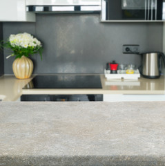 Empty kitchen stone table top with modern kitchen in background