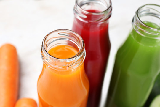 Bottles with various fresh vegetable juices, closeup