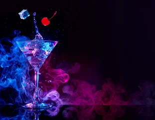 Abwaschbare Fototapete Cocktail Martini-Cocktail, der in blauem und violettem rauchigem Hintergrund spritzt