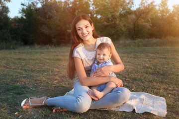 Beautiful young mother with cute baby boy, outdoors