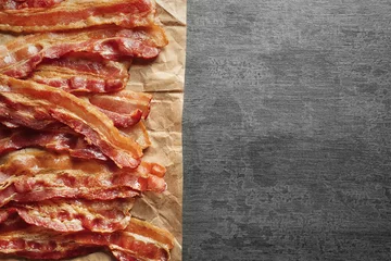 Gartenposter Parchment with cooked bacon rashers on table © Africa Studio