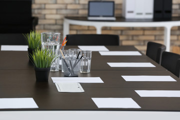 Big table with sheets of paper, indoors