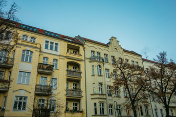 Fototapeta na wymiar yellow apartment buildings in berlin with blue sky