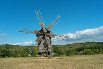 Fototapeta na wymiar Old fashioned wooden wind mill.