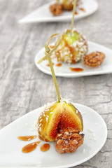 Ripe fig and walnut served with caramel sauce on plate