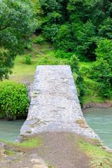 The stone arched bridge over the mountain river in Georgia