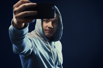 Professional hacker taking selfie on dark background
