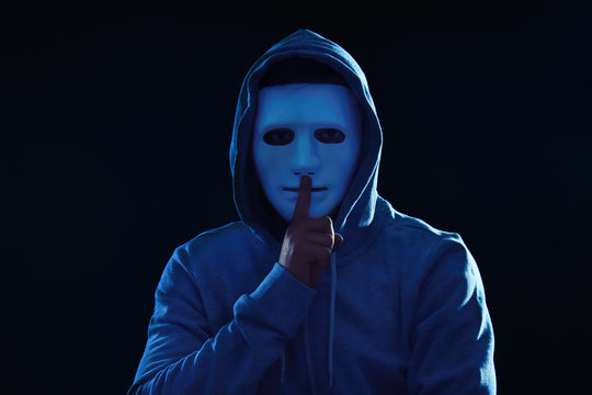 Hacker in mask on dark background