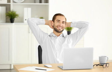 Attractive man with laptop in office