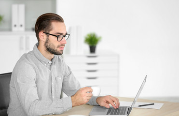 Attractive man with laptop in office