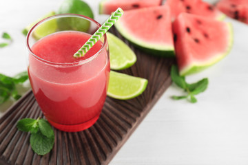 Glass with fresh watermelon smoothie on table