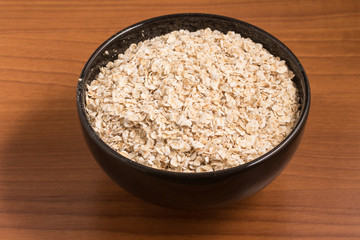 Oats flakes in a black bowl