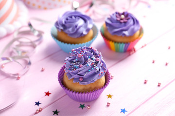 Tasty colorful cupcakes on wooden table
